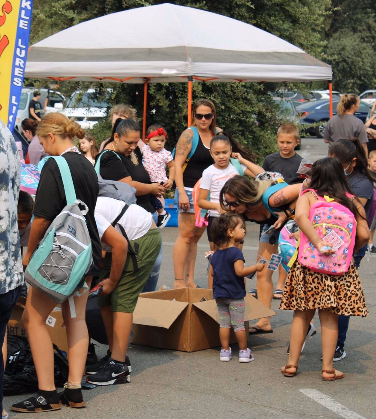 Children receiving school supplies from Mike Walker Lumber's Konnected Backpack Giveaway